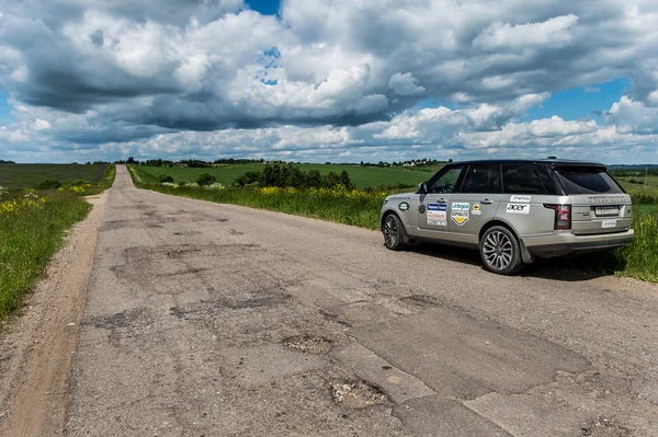 Suv car on a broken russian road — Stock Photo, Image