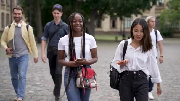 Positive multiracial students chatting during walk — Stock Video