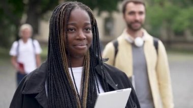 Utangaç Afro-Amerikan kız öğrenci dışarıda dolaşıyor.