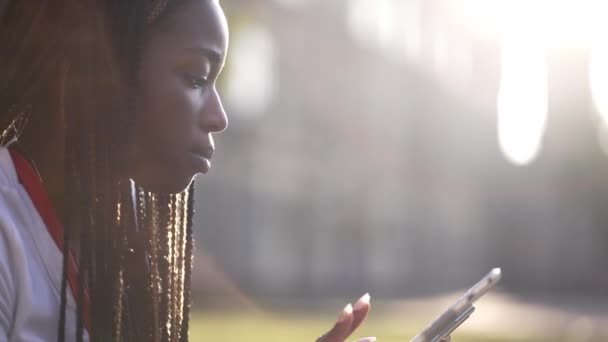 Konzentrierte dunkelhäutige Studentin studiert im Freien — Stockvideo