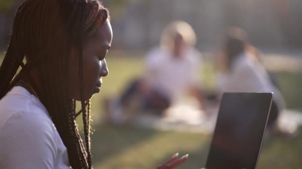 Multiraciale partners die laptops gebruiken die in de natuur studeren — Stockvideo