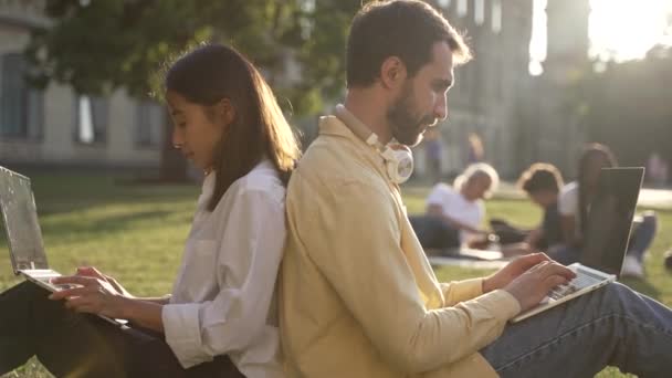 Jonge vrouw en man studenten tijdens de studie buiten — Stockvideo