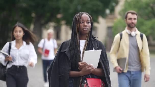 Wieloetniczni studenci uczęszczający na zajęcia przez kampus — Wideo stockowe