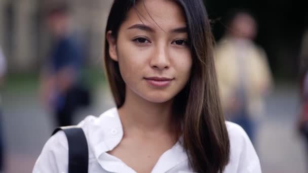 Jolie asiatique fille étudiant posant sur caméra extérieure — Video