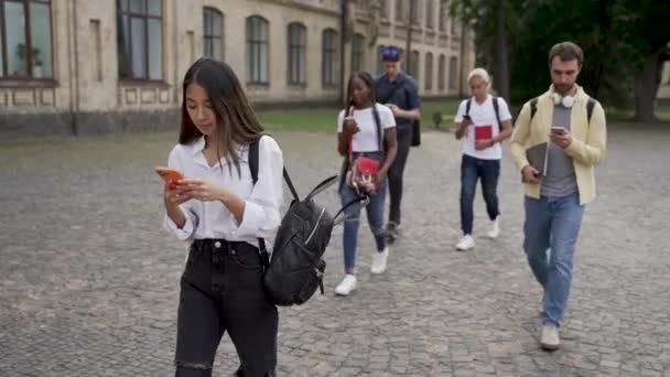 Зависимость от гаджетов студенты прогулки на открытом воздухе — стоковое видео