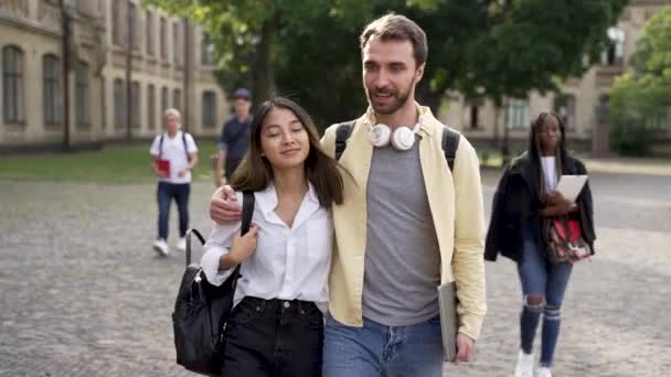 Fröhliches Studentenpaar unterhält sich beim Spaziergang — Stockvideo