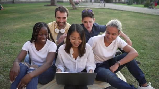 Estudiantes alegres charlando en línea en el ordenador portátil al aire libre — Vídeo de stock