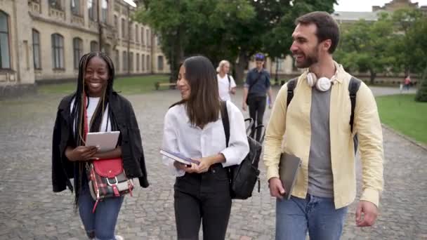 Vidám egyetemisták csevegnek az egyetemi parkban — Stock videók
