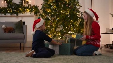 Neşeli çocuklar Noel arifesinde hediye seçiyor.