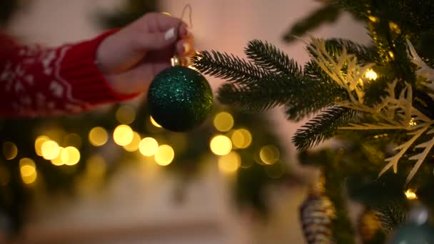 Tangan gadis tergantung bola Natal di pohon cemara — Stok Video