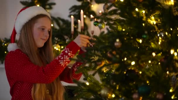 Menina bonita decorando abeto na véspera de Natal — Vídeo de Stock