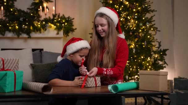 フレンドリーな妹と弟包装クリスマスギフト — ストック動画