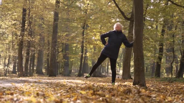 Healthy old woman doing sports exercises in nature — Wideo stockowe
