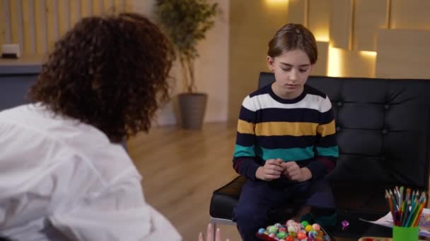 Çocuk hastaları test etmek için renkli toplar kullanan bir terapist. — Stok video