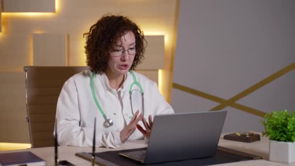 Female doctor consulting patient online at laptop — Stock Video