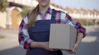 Dışarıdaki kamerada poz veren çekici teslimatçı kadın.