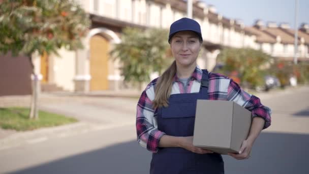 Sorridente corriere femminile consegna posa sulla macchina fotografica — Video Stock