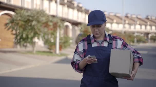 Kobieta pracownik dostawy z pudełka na zewnątrz — Wideo stockowe