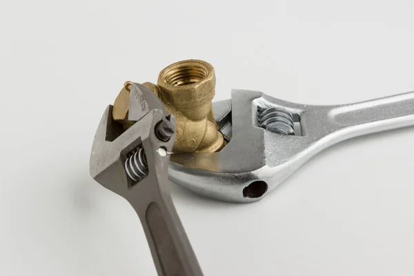 Llave ajustable y un tubo — Foto de Stock