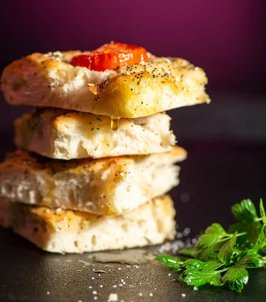 Çeri domates, haşhaş ve susam tohumları, biber, Himalaya kaya tuzu ve karışık bitkilerle taze pişmiş Focaccia.. 