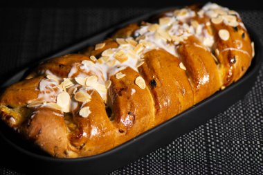 Muhallebi ve doğranmış elma ile doldurulmuş tatlı meyve kütüğü, çörekle fırçalanmış ve beyaz fondöten ve gevrek bademlerle kaplanmış..