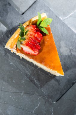 Taze nane ve dilimlenmiş çilekli ev yapımı geleneksel peynirli kek..