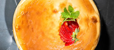 Taze nane ve dilimlenmiş çilekli ev yapımı geleneksel peynirli kek..