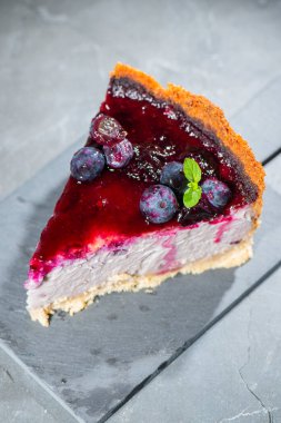 Homemade blueberry cheesecake with fresh blueberries, compote, and mint.