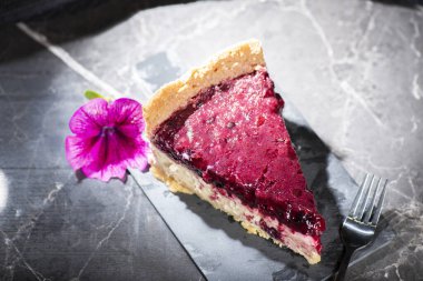 Homemade mixed berry cheesecake with a biscuit crumb and fruit puree.