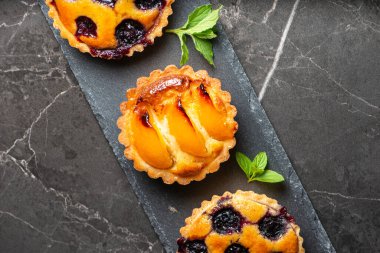 Taze yapılmış yabanmersini ve kayısılı Frangipane tartları.