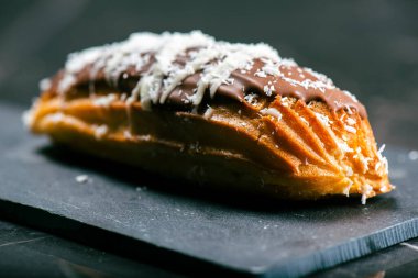 Ev yapımı mango ve hindistan cevizi kremalı ekler. Sütlü çikolataya batırılmış.