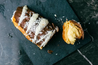 Ev yapımı mango ve hindistan cevizi kremalı ekler. Sütlü çikolataya batırılmış.