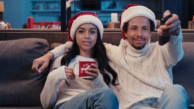 Mutlu Afro-Amerikan çifti Noel 'de film izliyor. 