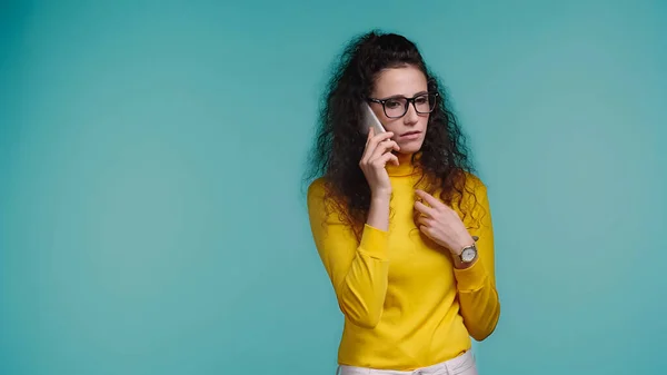 Kręcone Młoda Kobieta Okulary Mówi Smartfon Odizolowany Niebieski — Zdjęcie stockowe