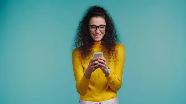 Alegre Joven Mujer Gafas Mensajes Texto Teléfono Inteligente Aislado Azul — Foto de Stock