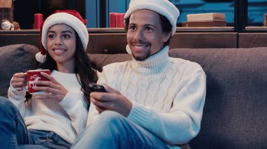 Mutlu Afro-Amerikan erkek ve kadın Noel 'de film izliyor. 