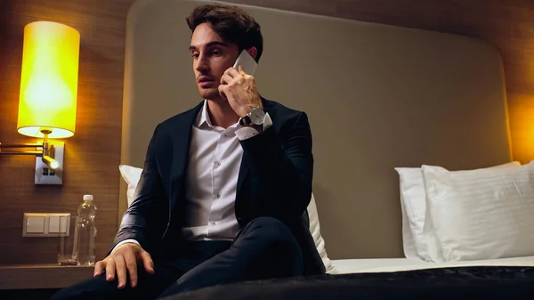 Hombre Negocios Sentado Cama Hablando Teléfono Inteligente Habitación Hotel — Foto de Stock