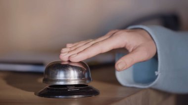 cropped view of woman pressing service bell on hotel reception counter clipart