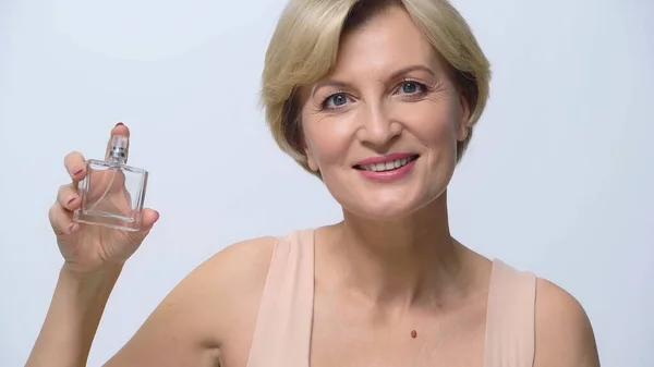 Complacida Mujer Mediana Edad Sonriendo Cámara Mientras Sostiene Perfume Aislado — Foto de Stock