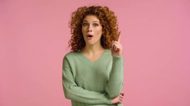 Şaşırmış bir kadın, ağzı açık, pembe üzerine izole edilmiş bir fikir jesti gösteriyor.