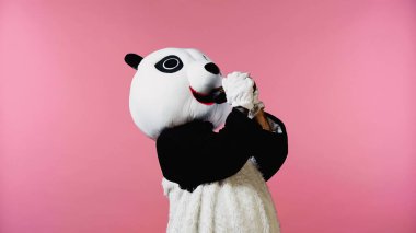 person in panda bear costume drinking wine isolated on pink  clipart