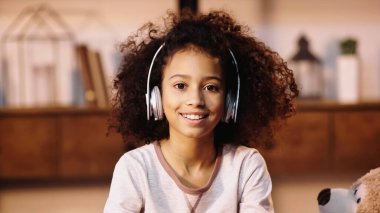 Mutlu Afro-Amerikan çocuğu kablosuz kulaklıkla müzik dinliyor. 