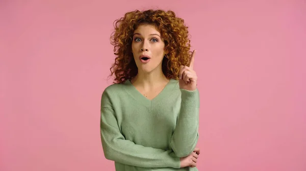 stock image amazed woman with open mouth showing idea gesture isolated on pink