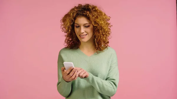 Радостная Женщина Кудрявыми Рыжими Волосами Помощью Мобильного Телефона Изолированного Розовый — стоковое фото