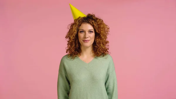 Cheerful Redhead Curly Woman Party Cap Looking Camera Isolated Pink — Stock Photo, Image