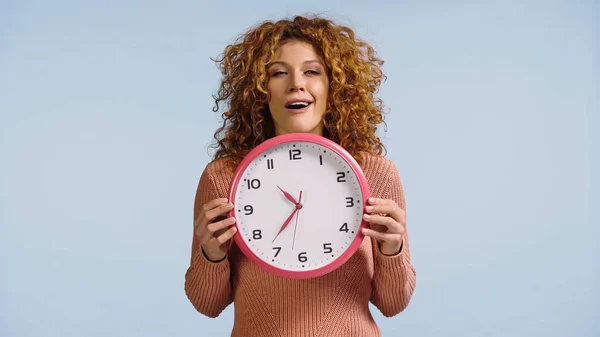 Tricky Woman Red Curly Hair Holding Clock Isolated Blue — Stockfoto