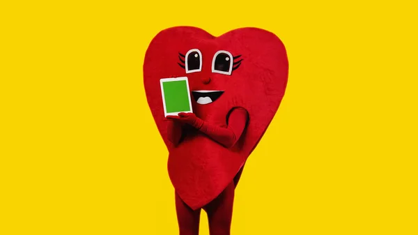 Kırmızı Kalp Kostümlü Kişi Elinde Yeşil Ekranlı Dijital Tablet Tutuyordu — Stok fotoğraf