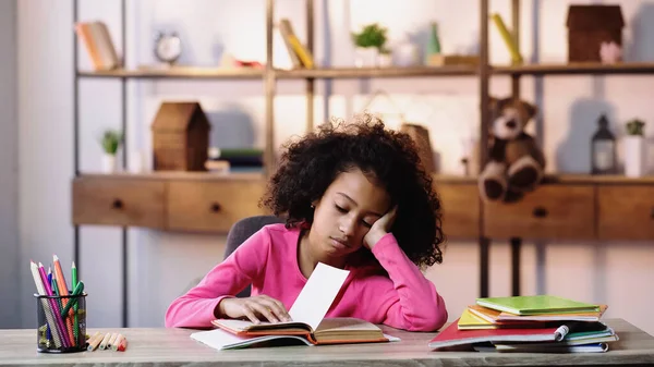 Znuděný Africký Americký Dítě Při Pohledu Knihu Při Provádění Domácích — Stock fotografie