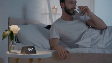Geceleri komodinin üstünde saatlerce su içen adam. 