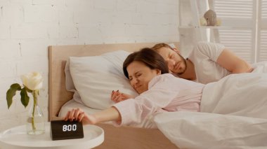 Memnuniyetsiz kadın evde uyuyan koca yakınındaki saati kapatıyor. 